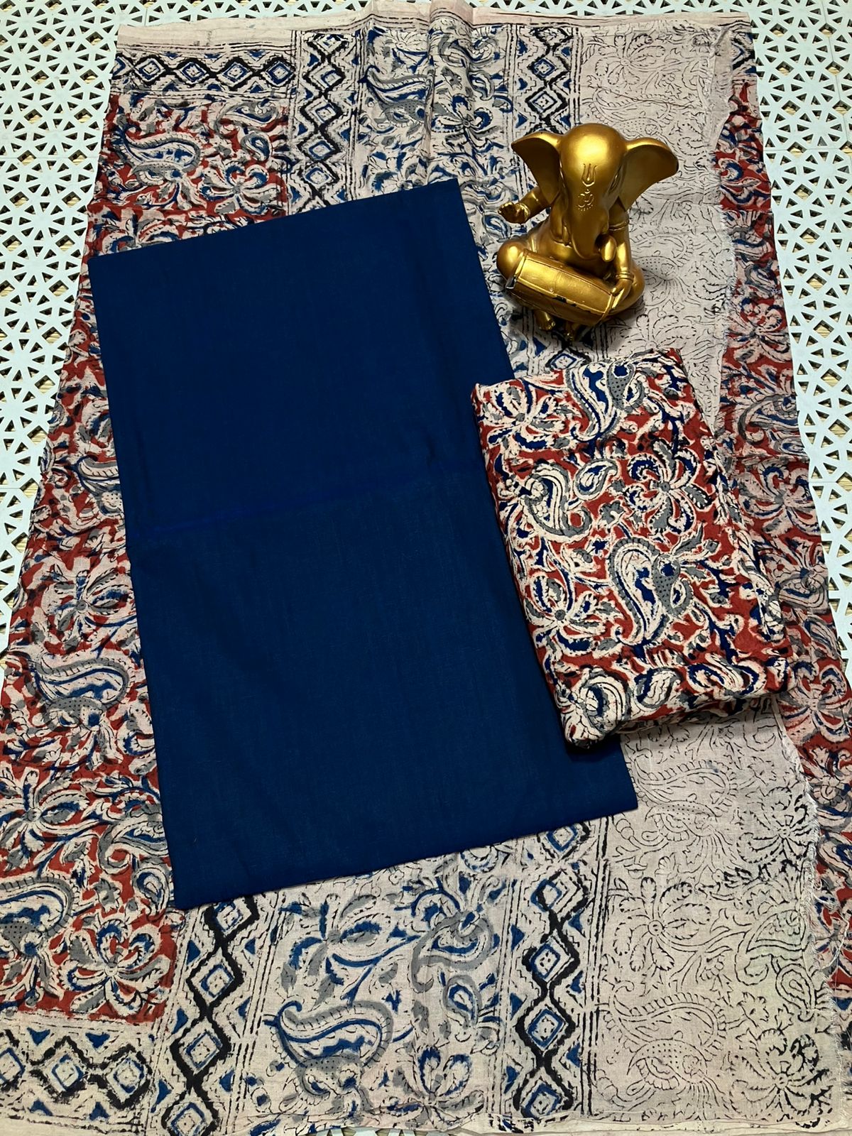 Blue fabric on a patterned fabric with a gold elephant figurine