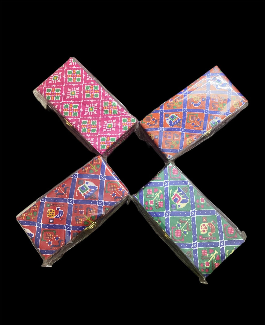 A set of four multicolored, geometric patterned Shagun boxes arranged in a cross formation on a dark background.