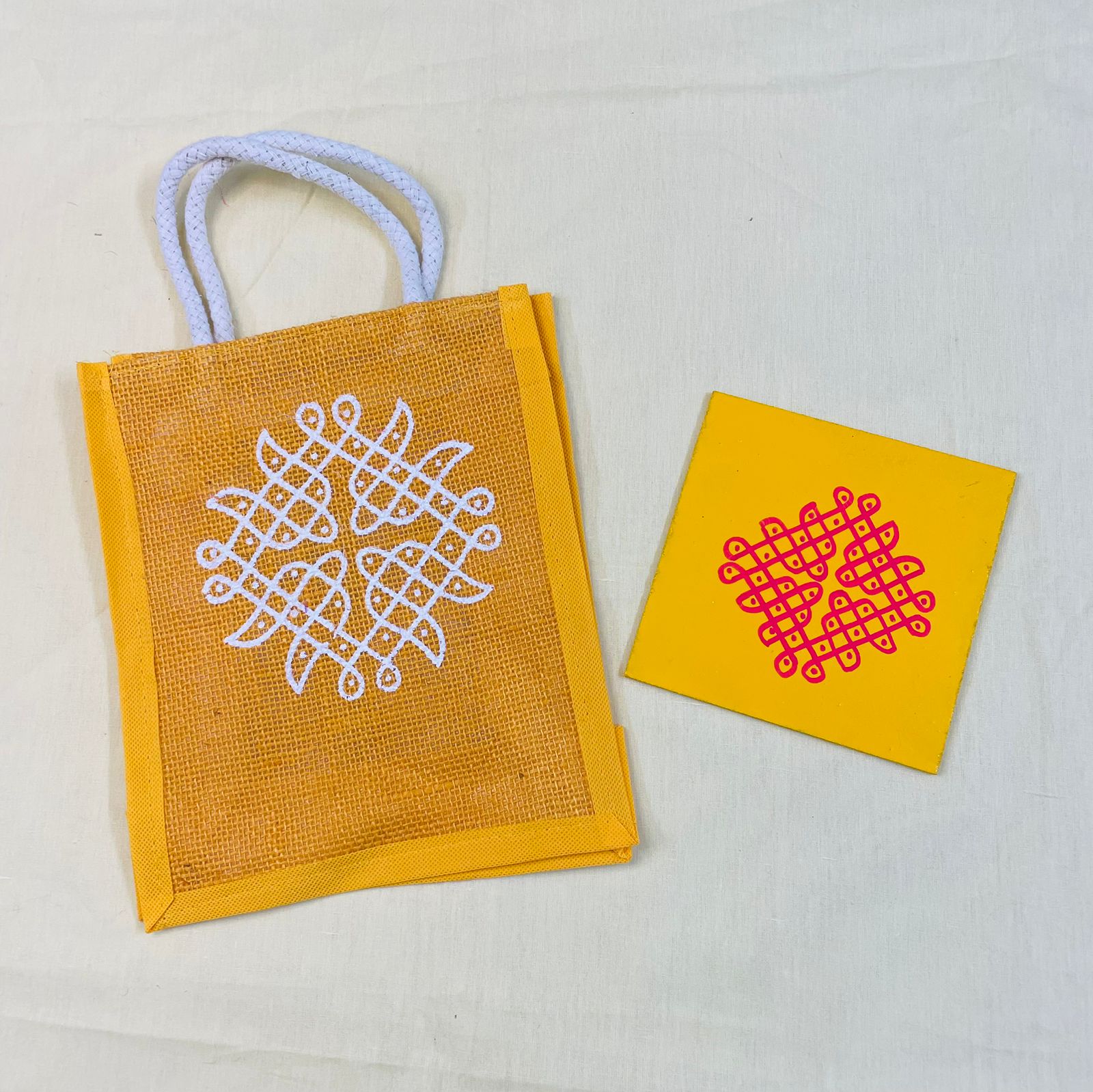 Yellow jute thamboolam bag with white Kolam print