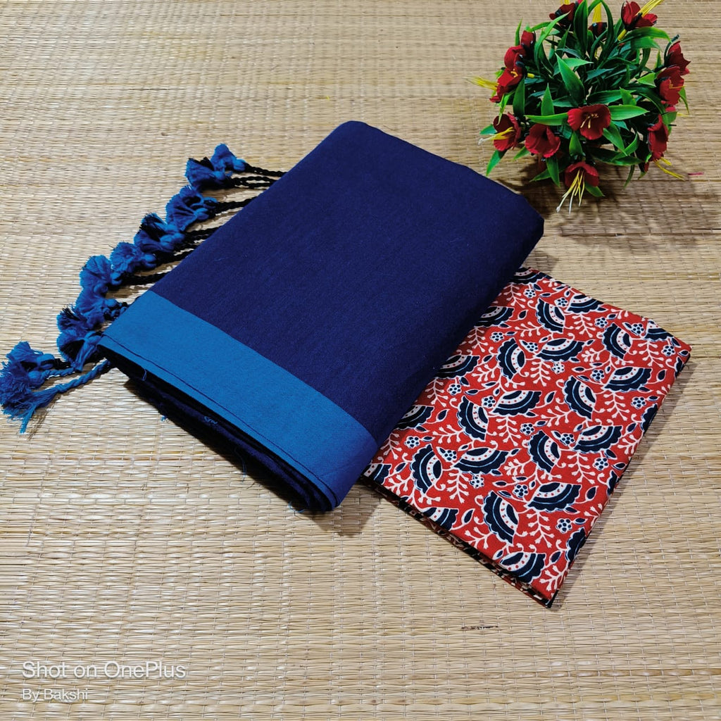 Blue fabric with tassels and a red and blue patterned fabric on a woven surface.